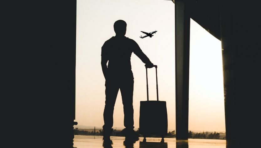 silhouette of man holding luggage inside airport